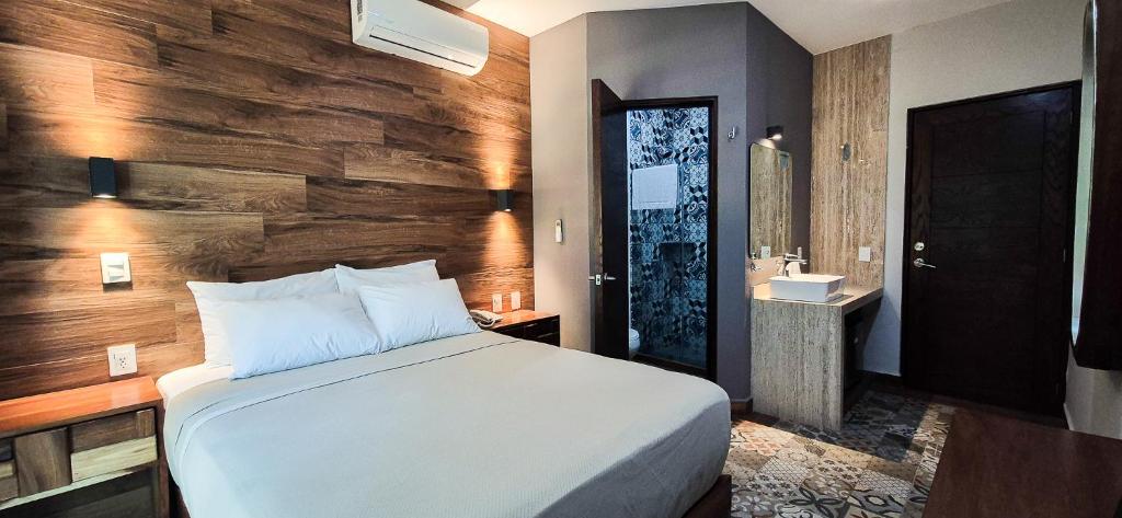 a bedroom with a bed and a bathroom with a sink at Gran Vila Nai Boutique Hotel in Guadalajara