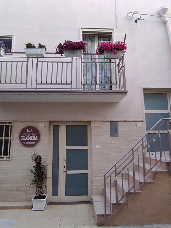 a building with a balcony with flowers on it at B&B Santa Filomena in Laterza