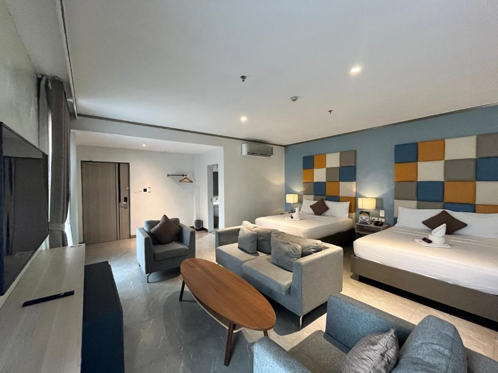 a hotel room with two beds and a living room at Yes Hotel San Ildefonso Bulacan in Buliran