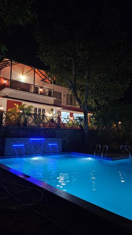 a large swimming pool at night with blue lights at Royal Heaven Wayanad in Ambalavayal