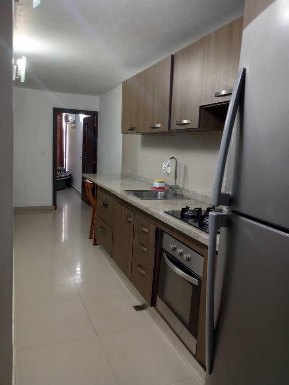 a kitchen with a stove and a refrigerator at Apartamento lechería in El Morto de Barcelona