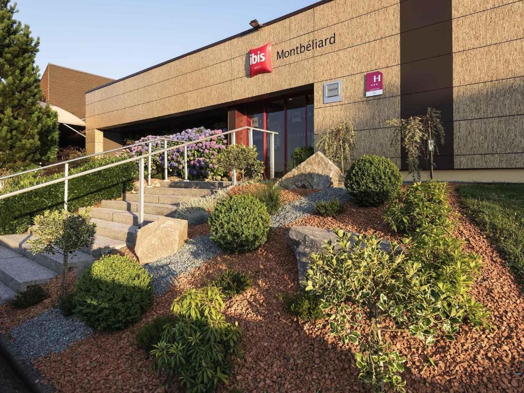 a building with a bunch of plants in front of it at ibis Montbéliard in Montbéliard