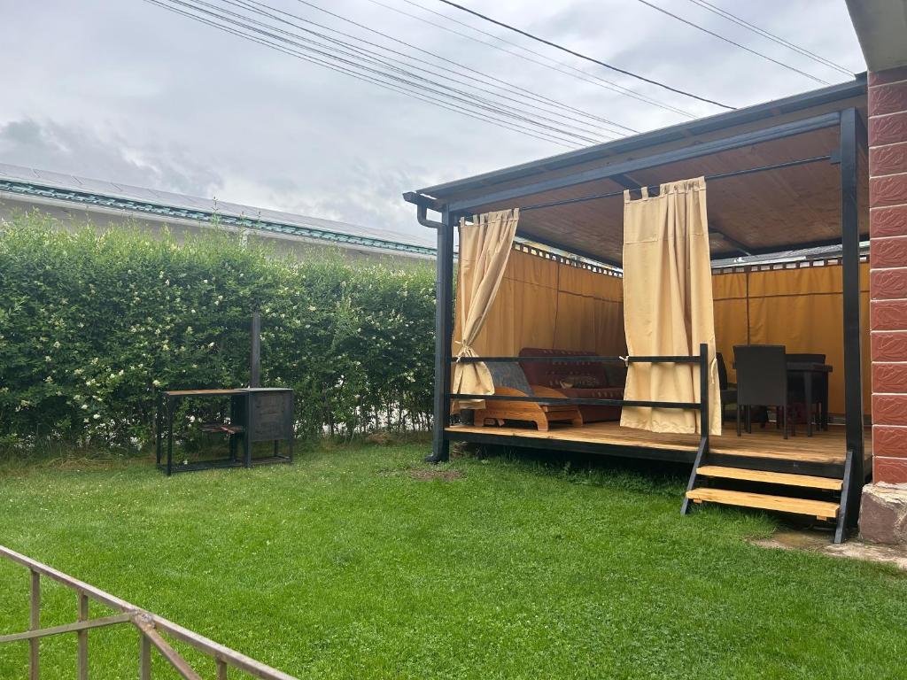 a gazebo with a couch and a table in a yard at Lovely House in Cholpon-Ata