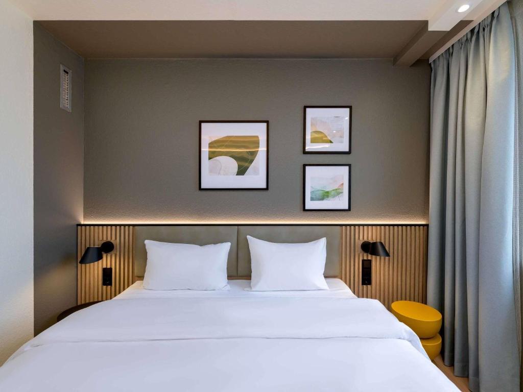 a bedroom with a large bed with two pillows at ibis Paderborn City in Paderborn