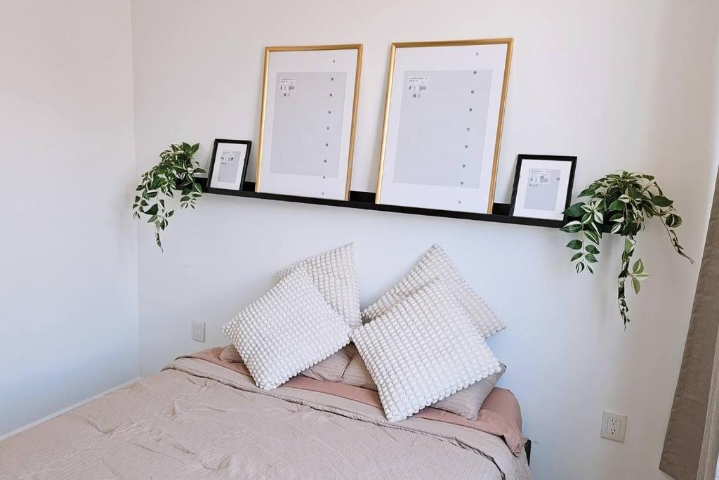 a bed with two pillows and a shelf on a wall at Tu espacio ideal en Intercity Urban Corridor in Querétaro