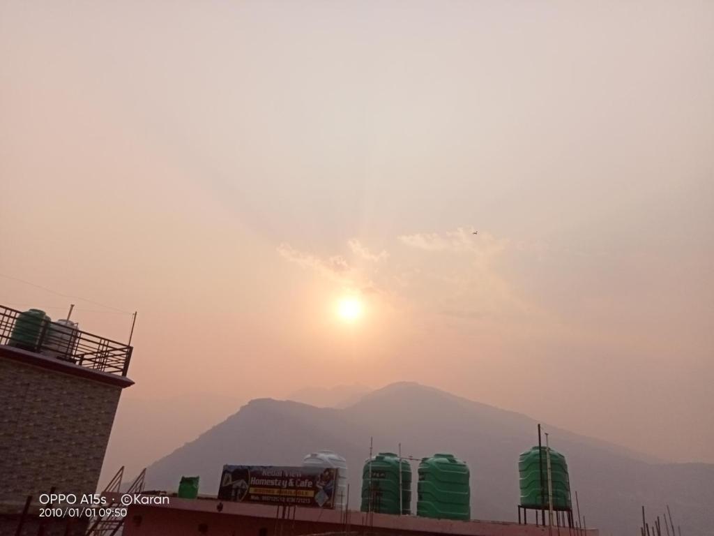 a view of the sun setting over a mountain at Chaukhamba hill homestay in Ukhimath