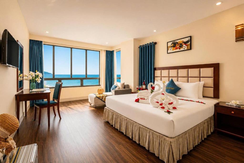 a hotel room with a large bed and a desk at Sea Front Apartment & Spa Da Nang in Danang