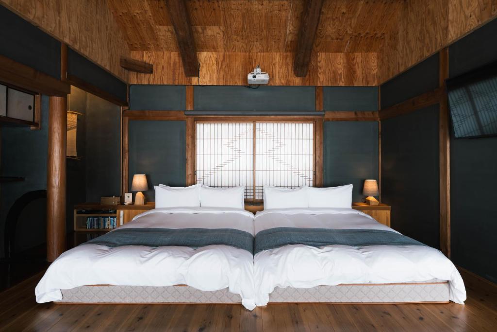 a bedroom with a large bed with a blue wall at CAFE & BB guri in Ine