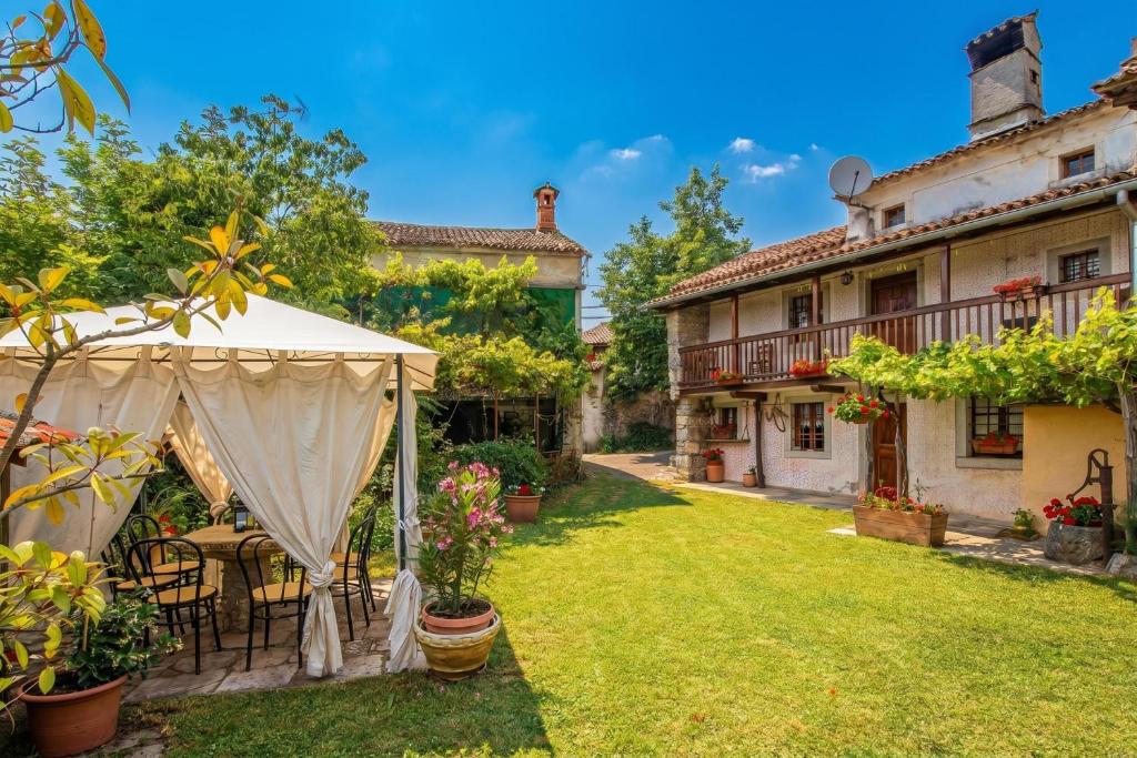 a garden with a tent and a house at Luin Country House near Štanjel - Happy Rentals in Štanjel
