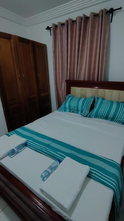 a bedroom with two beds with blue and white sheets at Sweet Inn Limbe in Limbe