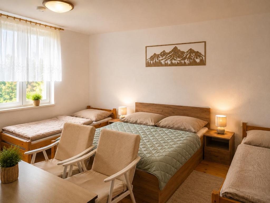 a bedroom with two beds and a table and chairs at Privat DAŇO in Lisková