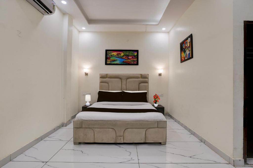 a bedroom with a large bed in a white room at Super Hotel O Clock Tower Dehradun Formerly Dooncity Suites in Dehradun
