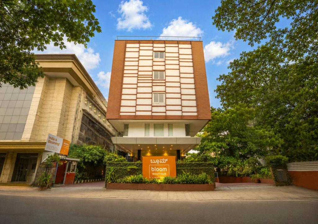 a tall building with a sign in front of it at Bloom Boutique Bangalore Palace Rd in Bangalore