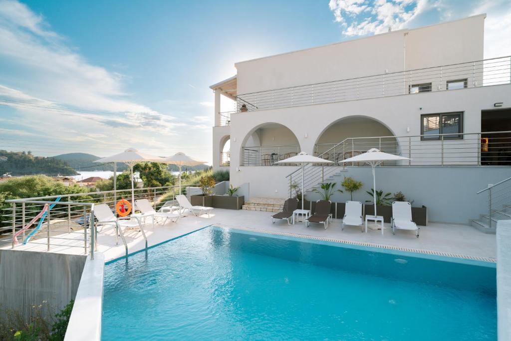 a swimming pool in front of a house at Ostria Village in Syvota