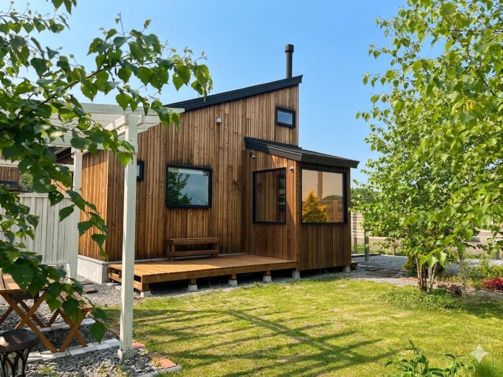 a small wooden house with a large window at mizuki natural villa Garden in Higashikawa