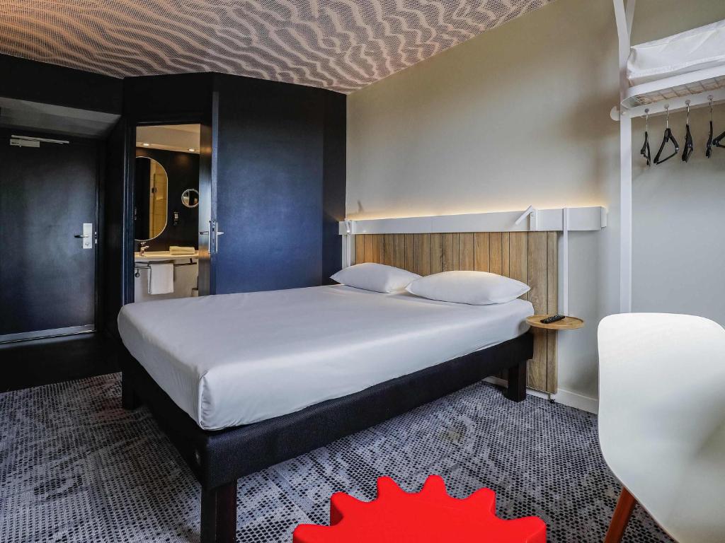 a bedroom with a large white bed in a room at Ibis Luxembourg Airport in Luxembourg