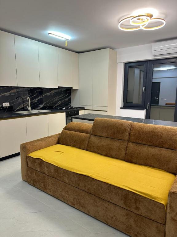 a couch with a yellow blanket on it in a kitchen at Apartament Magnolia Panoramic in Craiova