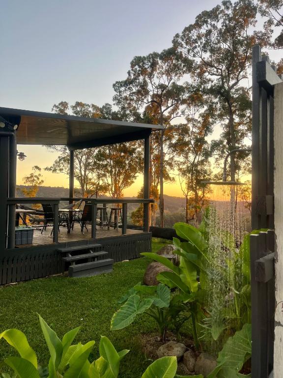 a patio with a picnic table and a sunset at El Rancho Cabarita Beach - Highlander in Clothiers Creek