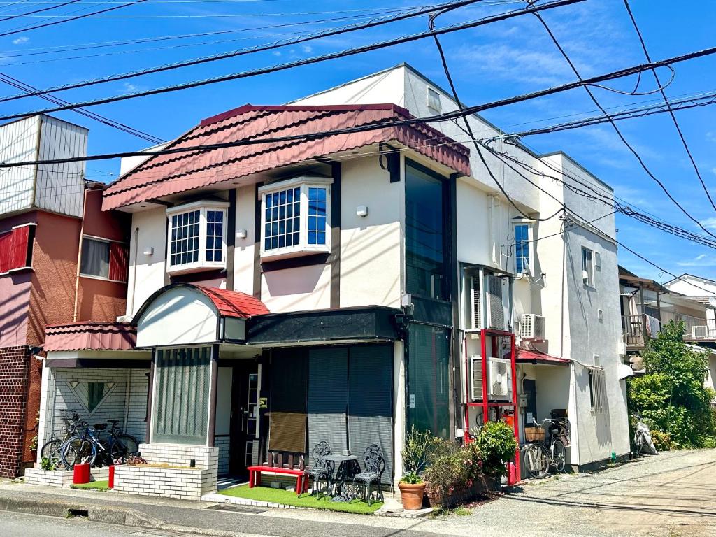 a house with a red roof on a street at 自遊人の宿 in Odawara