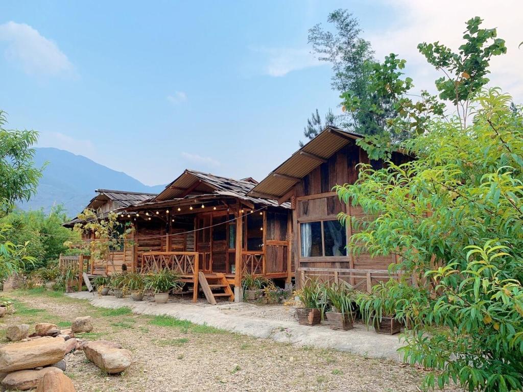 a wooden house in the middle of a forest at Nhà Gỗ Cạnh Suối in Bản Det
