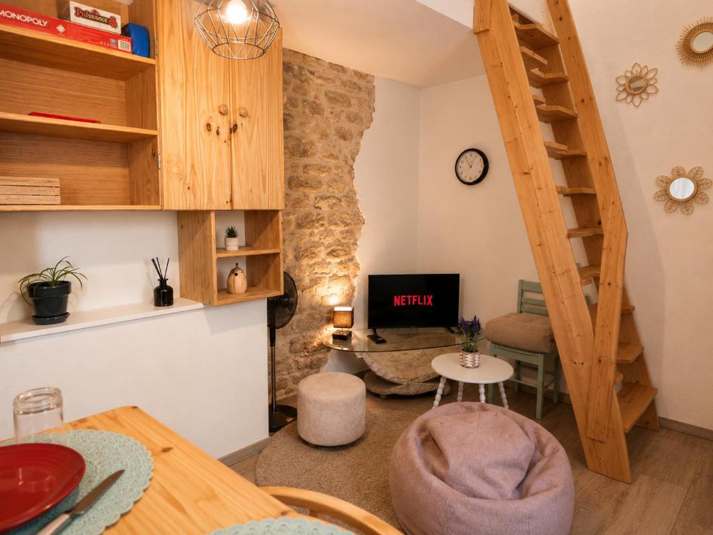 a small living room with a staircase and a desk at Duplex Le Doux Rêve in Dole
