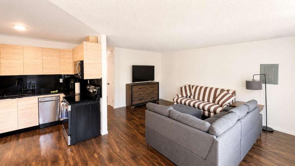 a living room with a couch and a kitchen at Mountain Views - Ocean Glimpses - Near Victoria - 2BR suite in Sooke