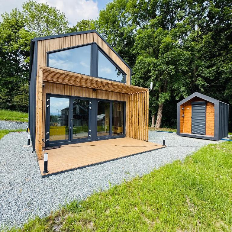 a tiny house with a large window on a sidewalk at Wilcza Osada Wellness Resort in Wilcza