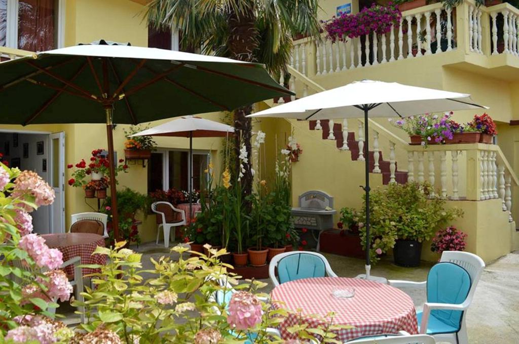 a patio with tables and chairs with umbrellas and flowers at Hostel David in Mostar