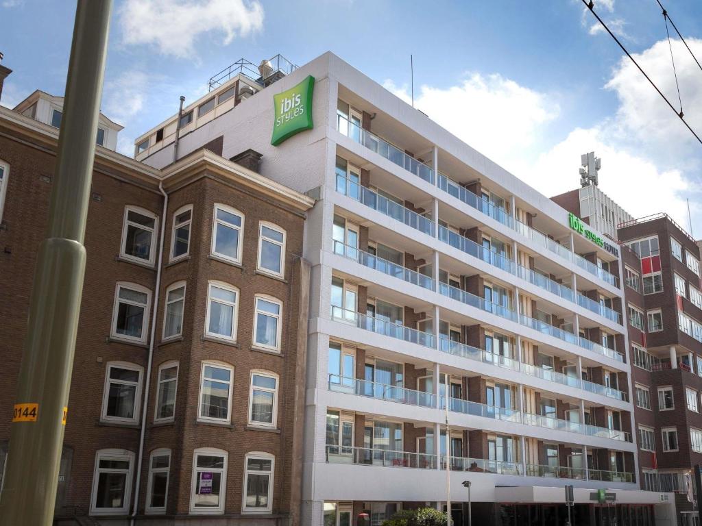 a large apartment building with a green sign on it at ibis Styles Den Haag Scheveningen in Scheveningen