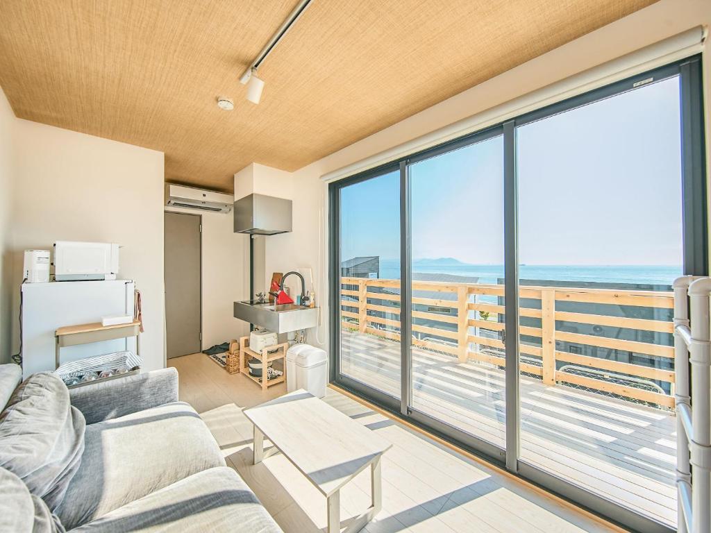 a living room with a couch and a view of the ocean at Awaji Dog Hill in Kusumoto