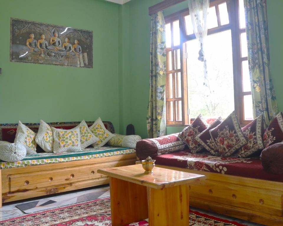 a living room with couches and a table and a window at Aama Homestay in Kurseong