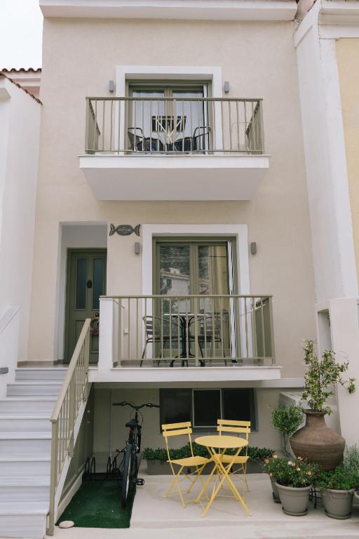 a building with two chairs and a balcony at Karamelaki in Pythagoreio