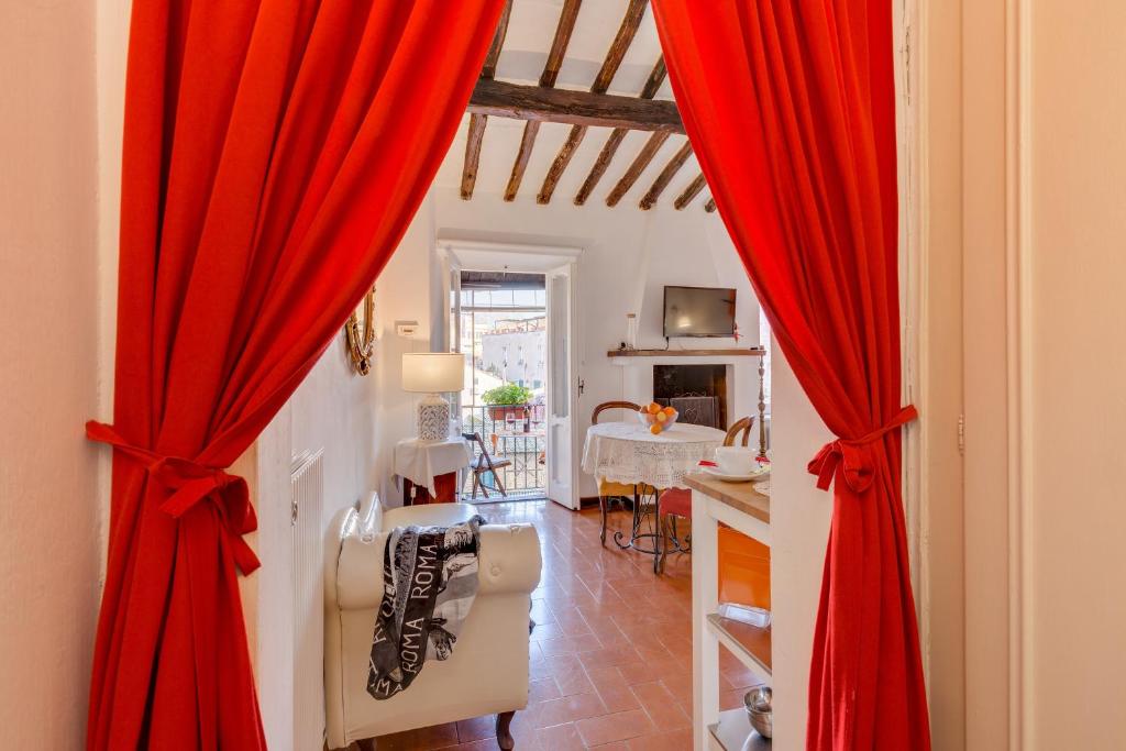 ローマにあるRoman Holiday Wine Houseの赤いカーテンとリビングルームが備わる客室です。