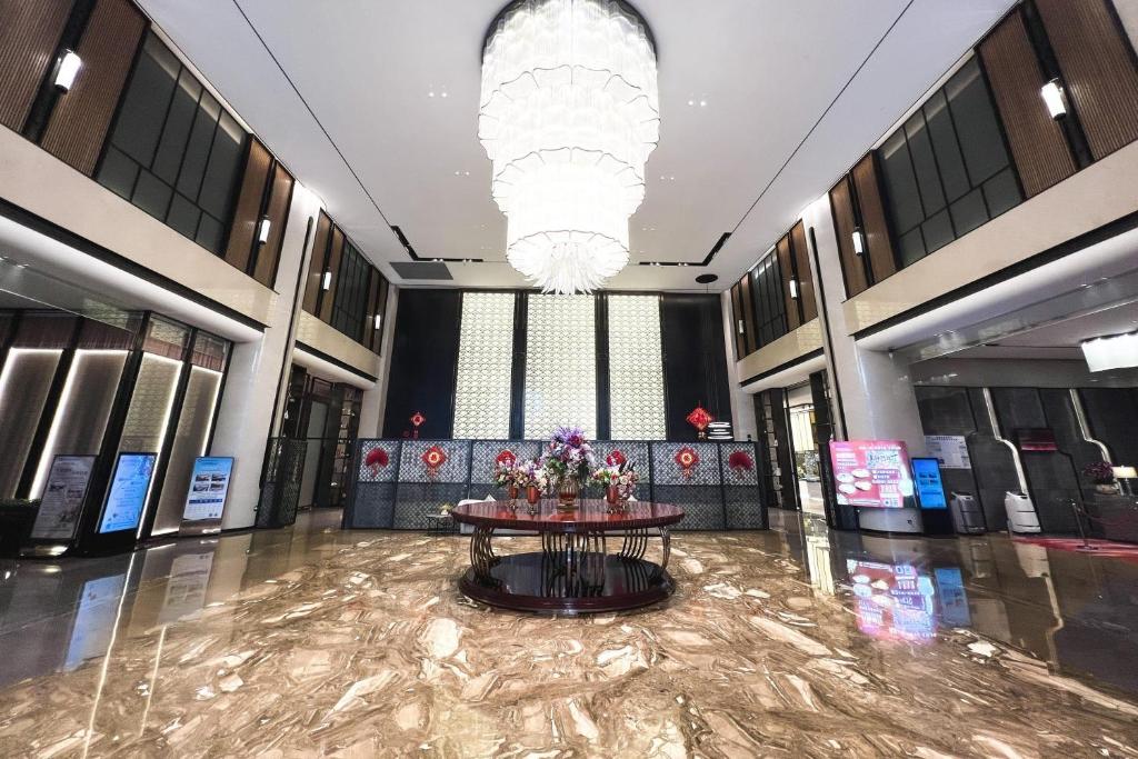 a lobby with a table in the middle of a building at Wyndham Shanwei Haifeng in Shanwei