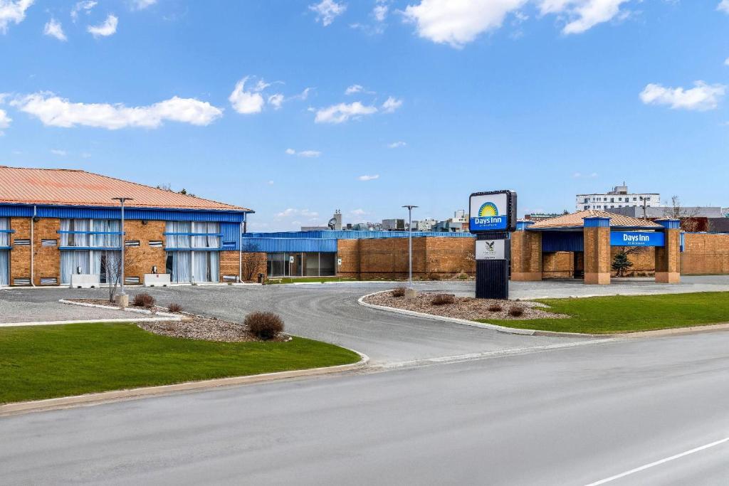 an empty road in front of a building with a gas station at Days Inn by Wyndham Sudbury & Conference Centre in Sudbury