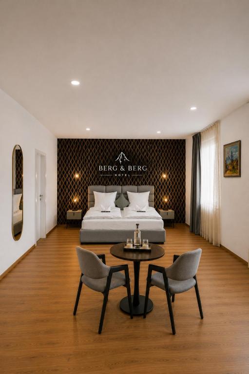 a bedroom with a bed and a table and chairs at BERG & BERG Hotel - Hellbühl Self-Check-in in Hellbühl