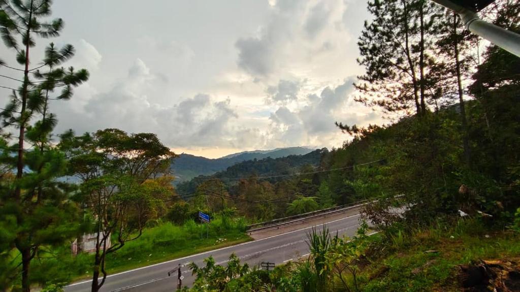 a view of a highway with trees and a mountain at AKI Backpackers in Ranau