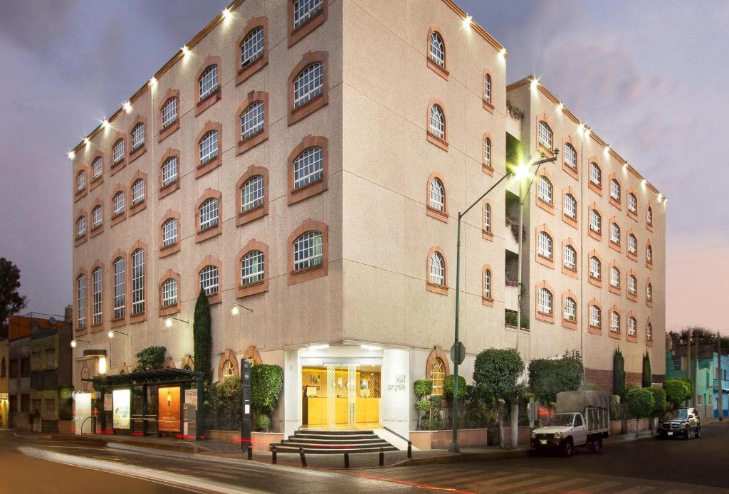a large building with yellow doors on a street at Hotel MX congreso CDMX, Trademark Collection by Wyndham in Mexico City
