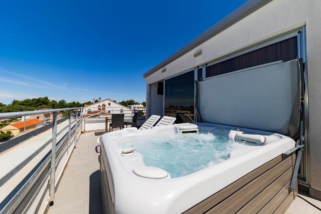 a hot tub on the balcony of a house at Villa Kovac in Zadar