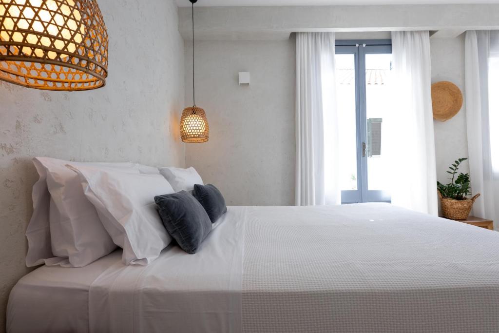 a bedroom with a large white bed with pillows at BOĒM Boutique Hotel Lefkada in Lefkada