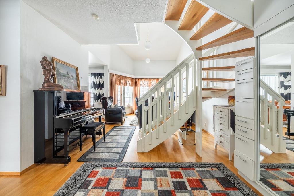 a living room with stairs and a piano at Pyynpesä ! in Rovaniemi