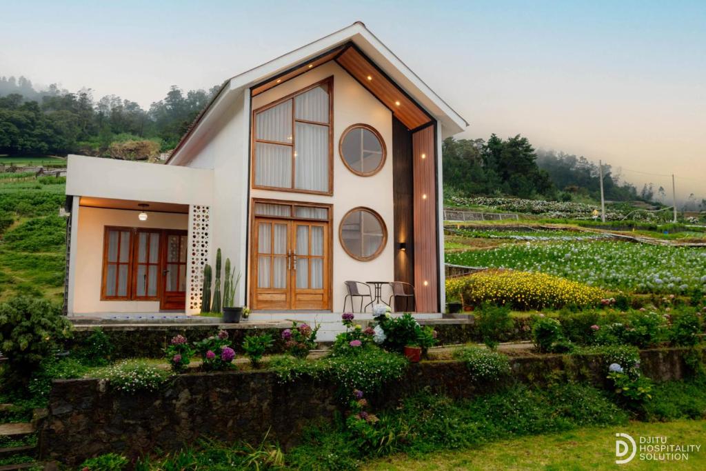 a small house in a field with flowers at Umacabana 2 in Diyeng
