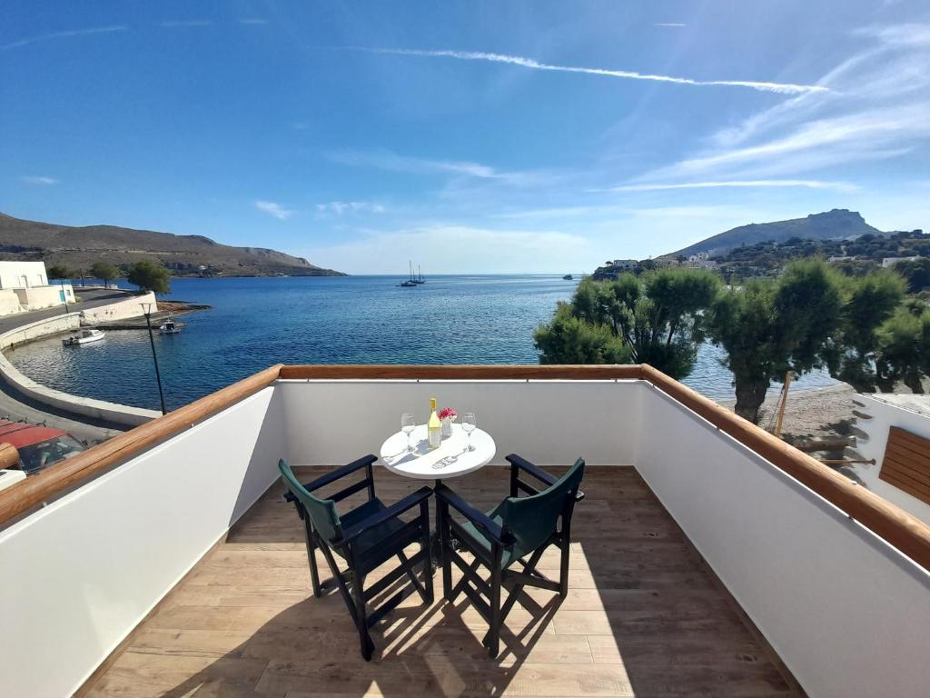 a table and chairs on a balcony with a view of the water at ELEVER Apartments in Agia Marina