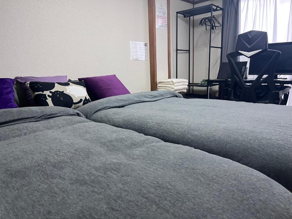 two beds sitting next to each other in a room at Cafe Sharehouse Kokoro Nest Kyoto in Kyoto