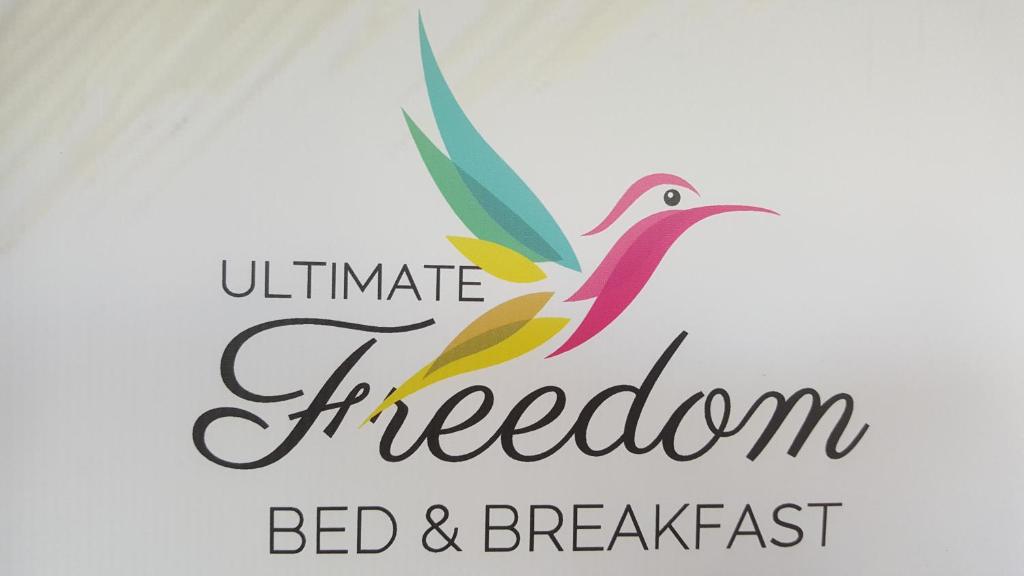 Ultimate Freedom Bed and Breakfast في Santa Cruz: شعار السرير والافطار مع وجود طائر
