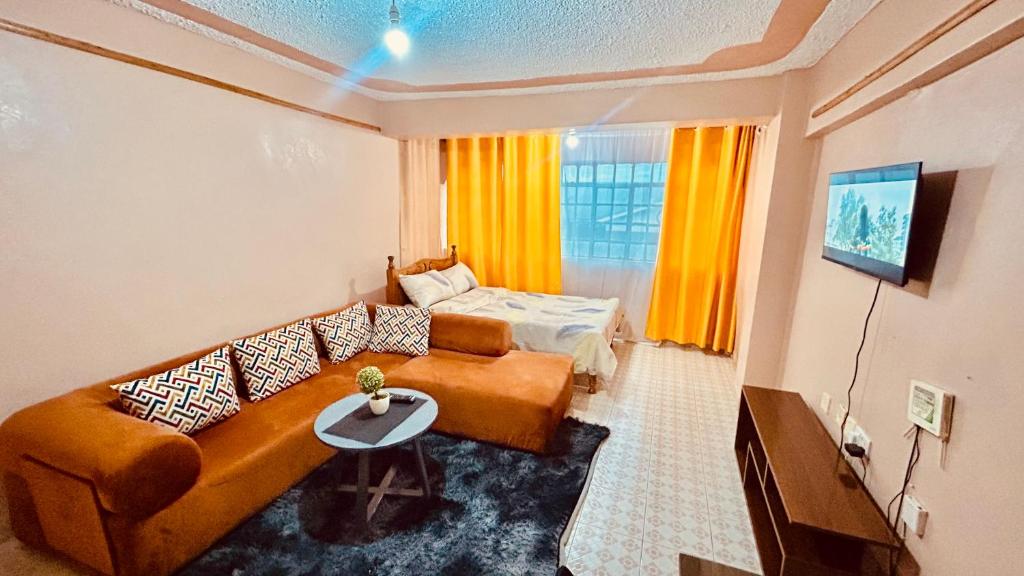 a living room with a couch and a bed at Ultimate retreat in Embu