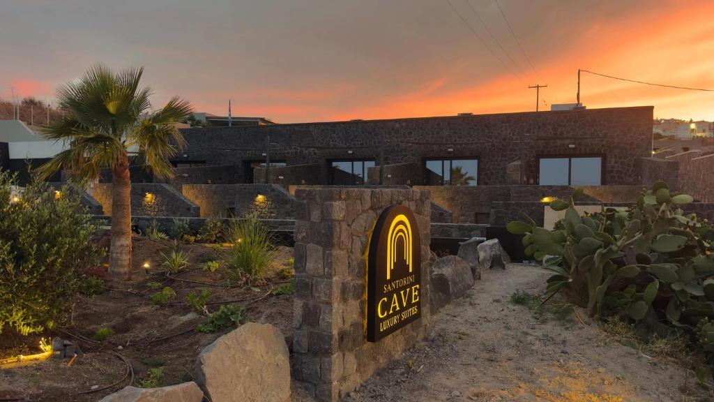 a restaurant with a sign in front of a building at Santorini Cave Luxury Suites in Fira
