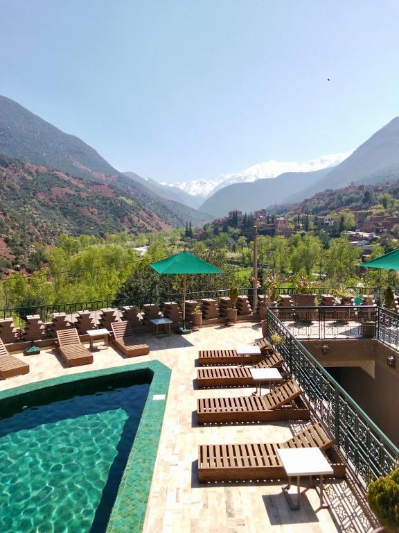 a resort with a pool and lounge chairs and mountains at La Kasbah d'Ourika - Hôtel Restaurant & Spa in Ourika