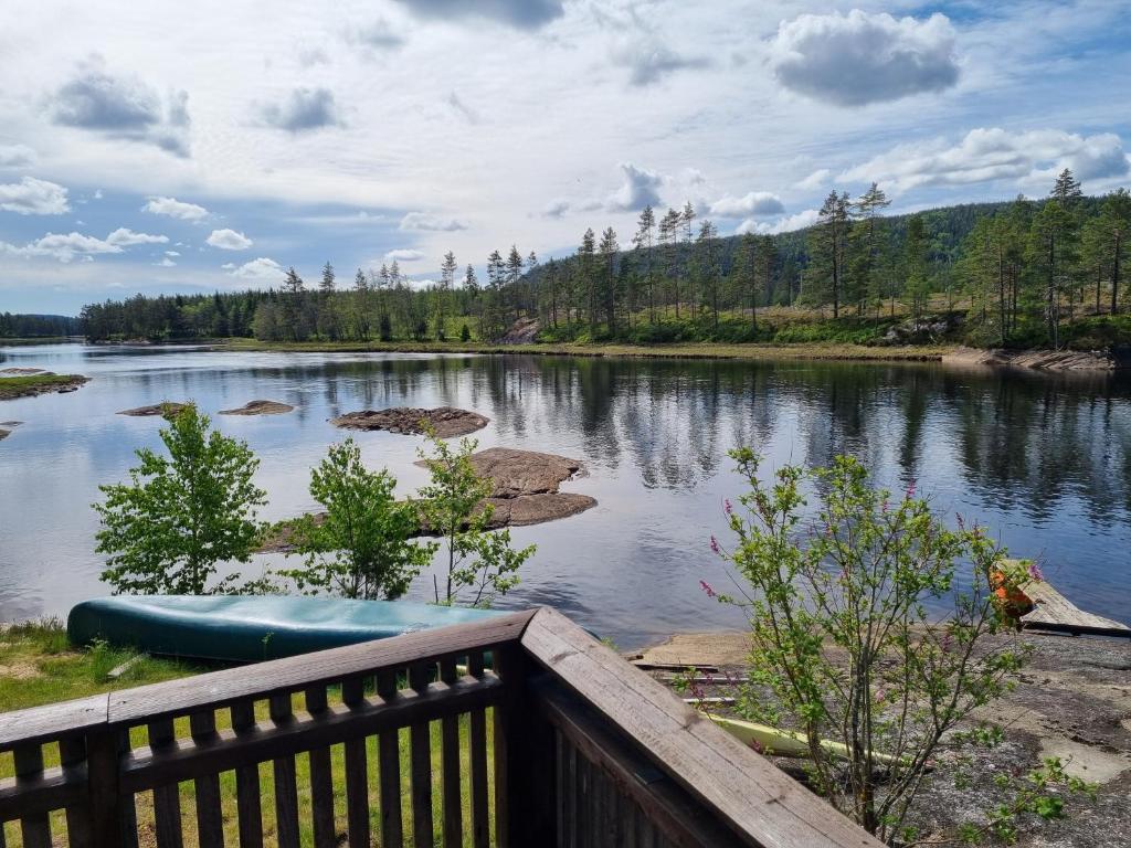 a view of a lake from a wooden deck at Bjørneboestova in Åmli