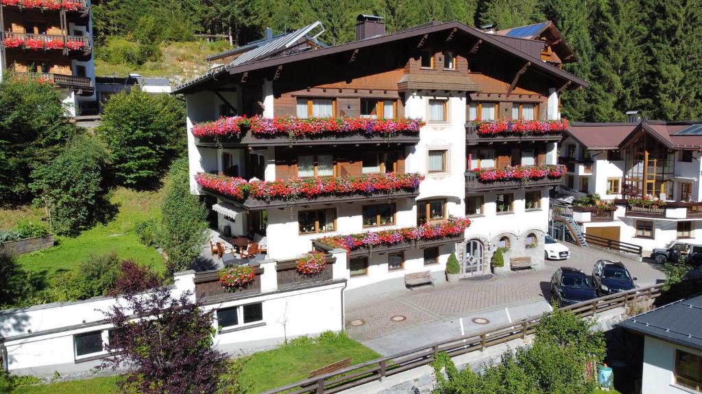 a large white building with flowers in the windows at Apart - und Frühstückspension Jägerheim in Kaunertal